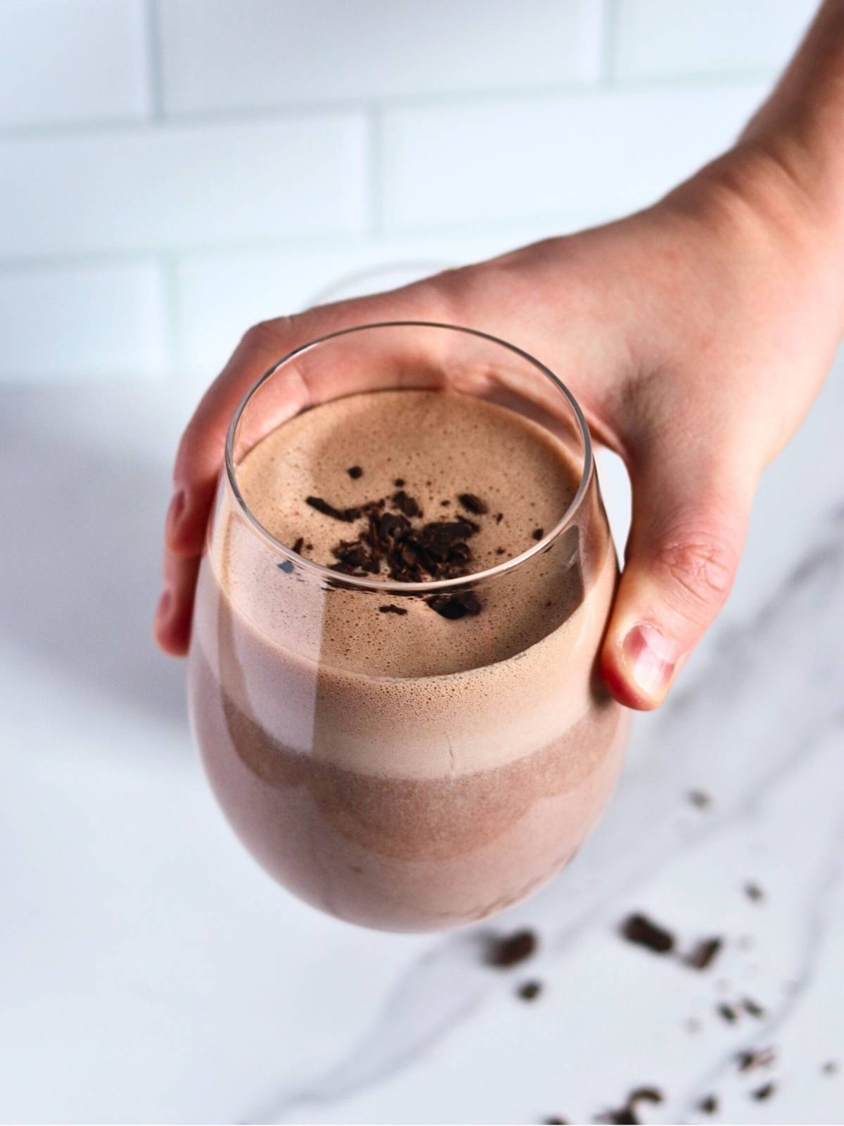 taking a glass of protein shake from the table.