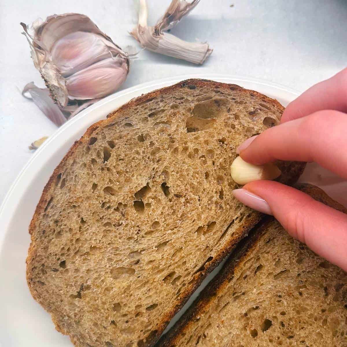 rubbing the toast with garlic glove.