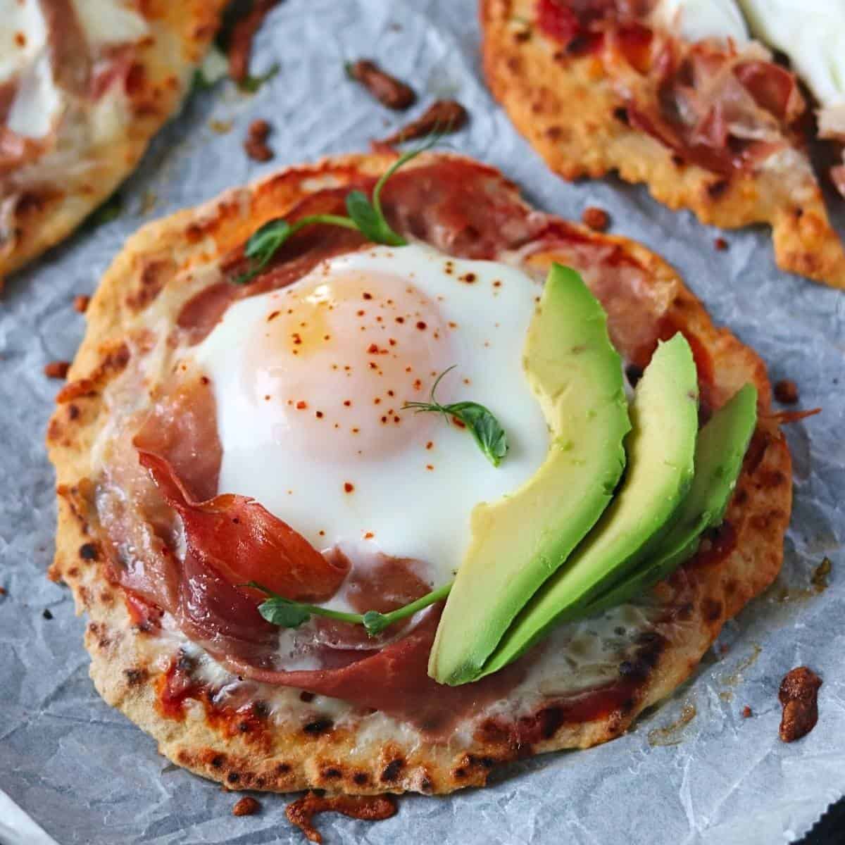 mini naan pizza baked, egg whites are set and the yolk is runny .