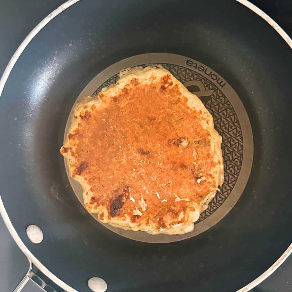 Cooking a protein pancake in a nonstick skillet until golden brown